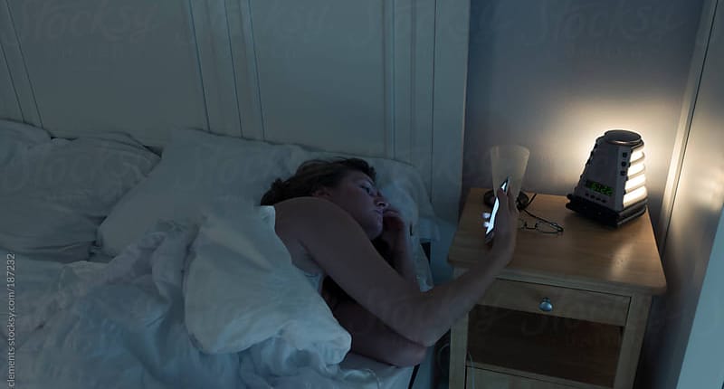 vrouw met telefoon in bed